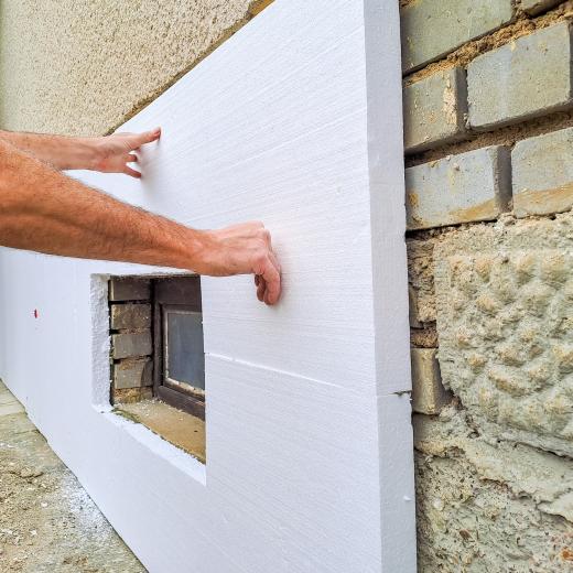 Mann arbeitet an einer Hausfassade