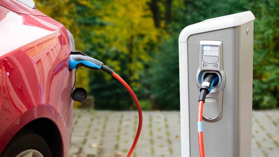 Nahaufnahme eines aufgeladenen Elektroautos an einer E-Ladestation